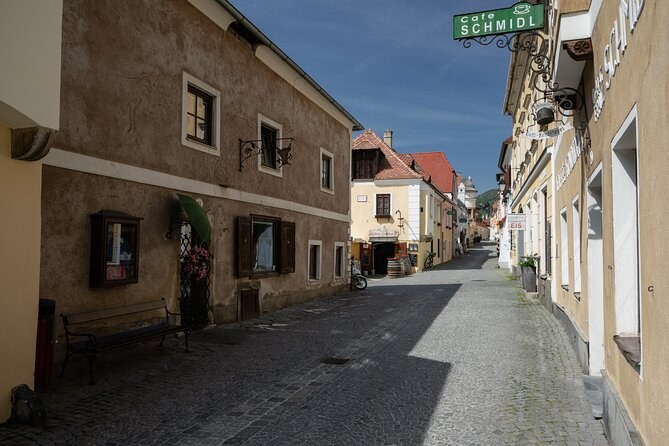 A cobbled lane of old houses under a green café sign reading Schmidl
