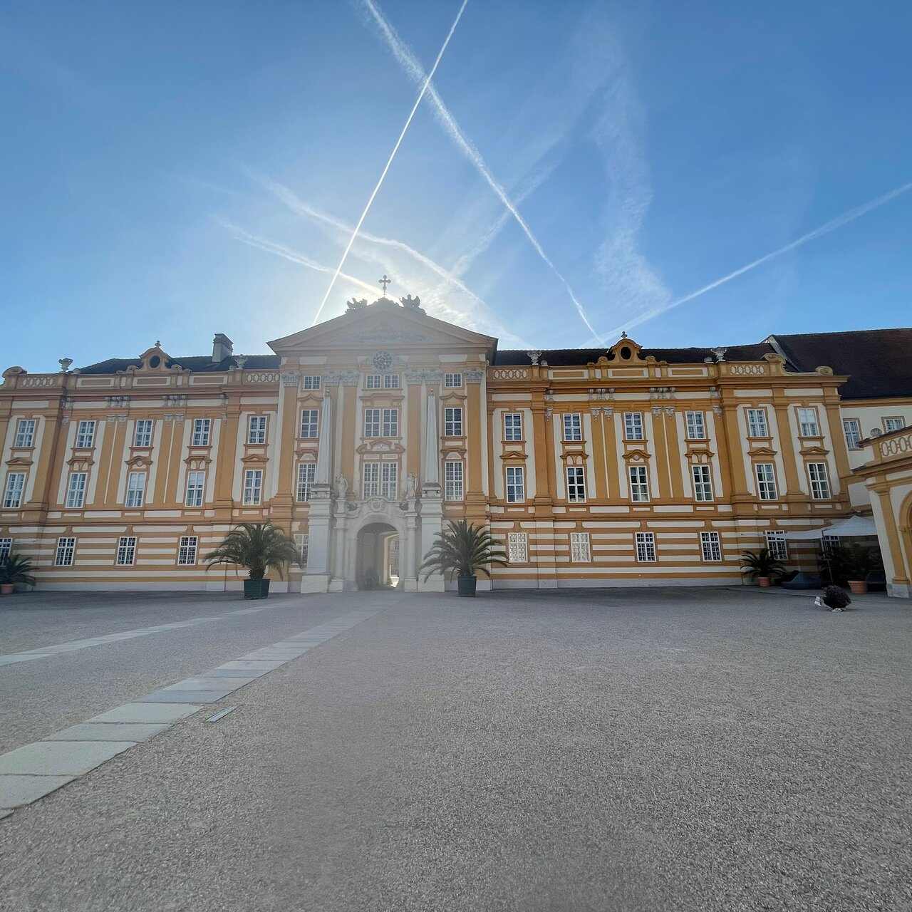 The long yellow front of Melk Abbey across its wide forecourt