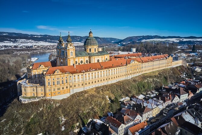 Melk Abbey from the air in winter, the town's roofs below and snow on the hills