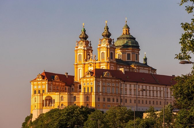 Melk Abbey's twin towers and dome lit gold by the evening sun