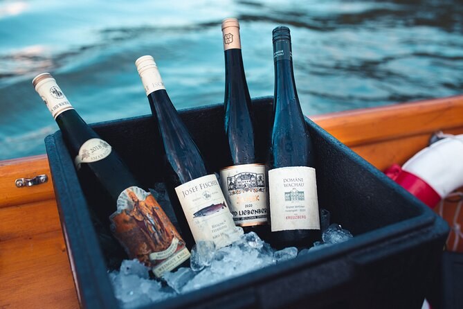 Bottles of white wine on ice aboard a wooden boat, Domäne Wachau among the labels